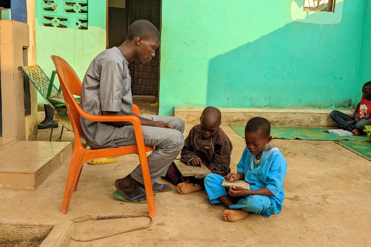 A Quranic teacher and two students during a lesson